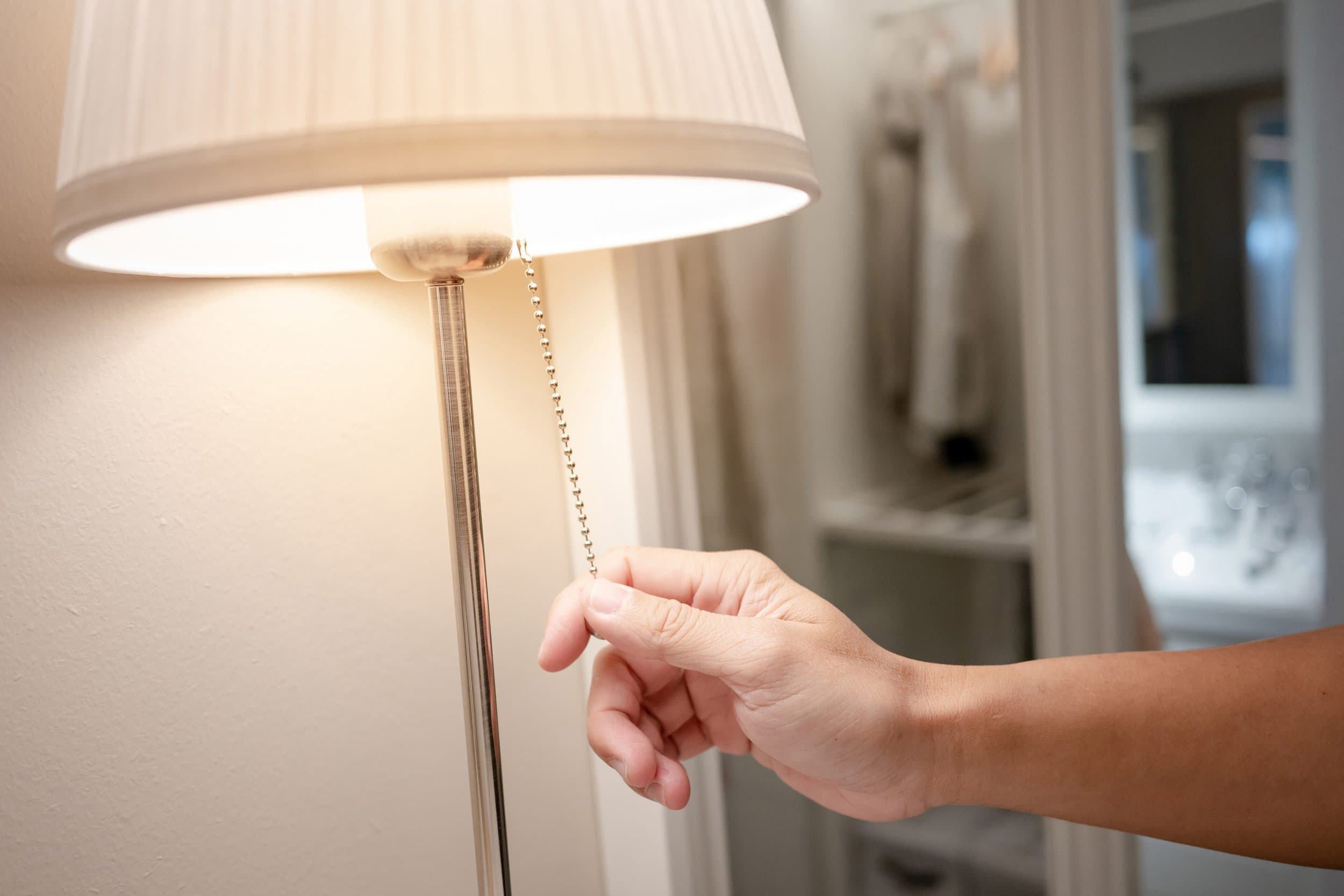 man turning on floor lamp